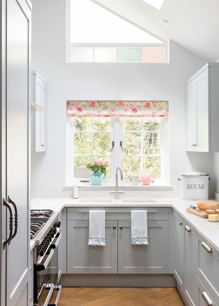 kitchen with floral blinds and wooden flooring