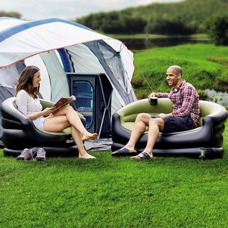man and women seating on inflatable sofa outdoor ion green lawn