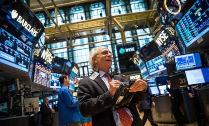 Traders work on the floor of the New York Stock Exchange at the end of the trading day on July 11. The Dow Jones Industrial Average closed at a record high.
