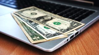 Money on a laptop used for best money transfer apps