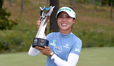 Lydia Ko holds a trophy and smiles