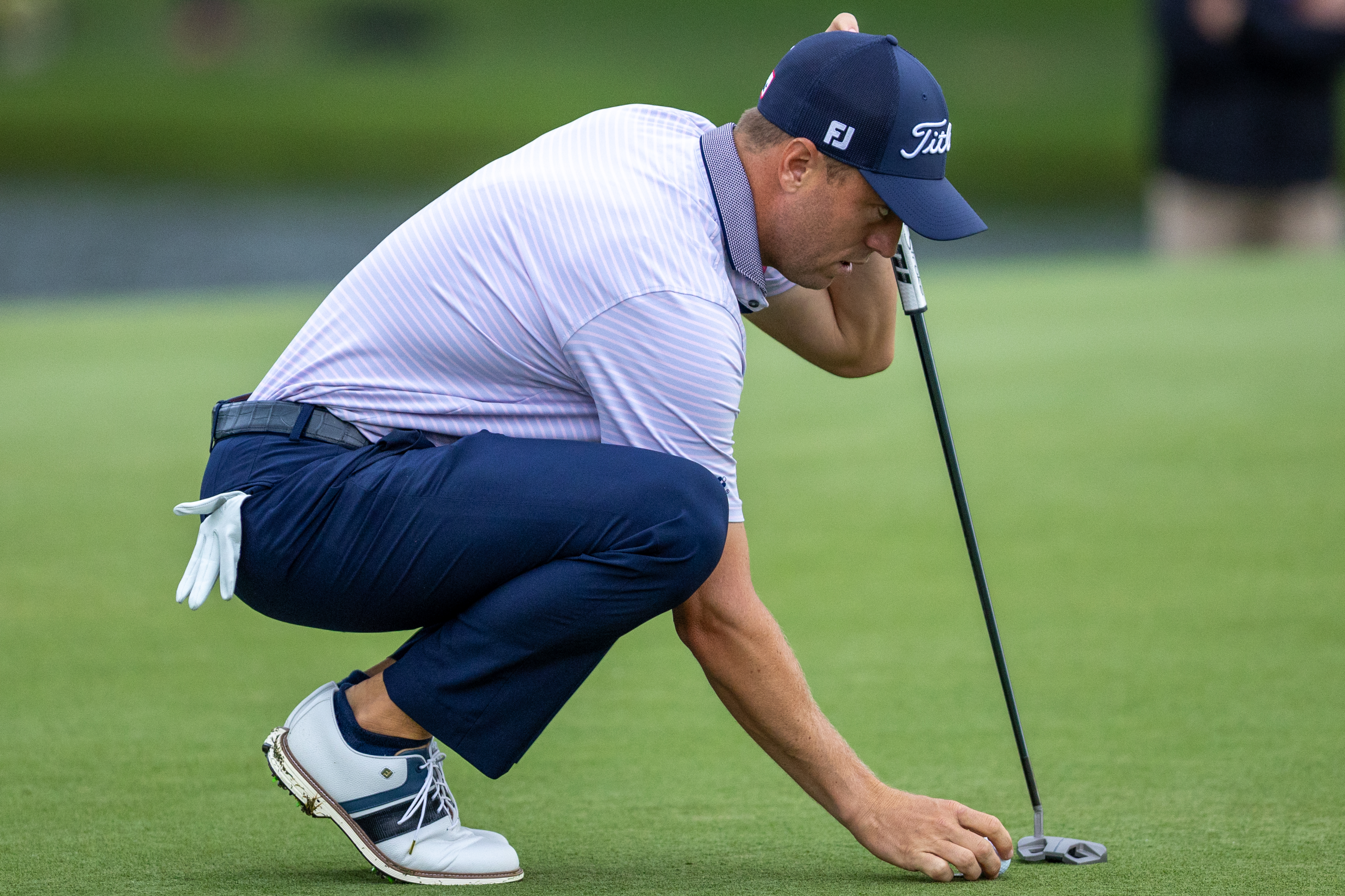 Justin Thomas places his ball on the green of the 16th hole during the first round of the Truist Championship