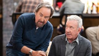 Season 2 Shifting Gears Press image of Richard Karn in a blue shirt sharing a drink with Tim Allen in a button down and grey suit coat.