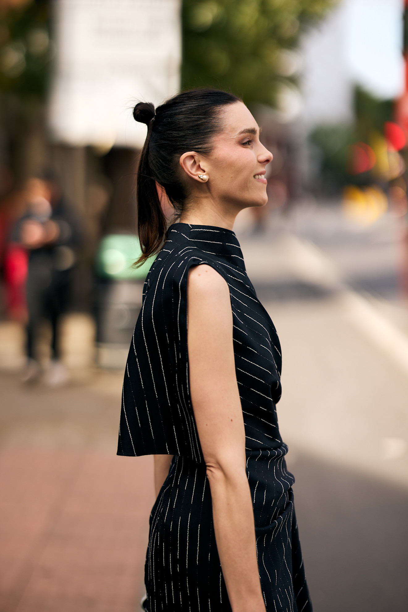 a white woman in a black striped dress with a small bun