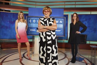Anne Robinson stands in the Countdown studio with Rachel Riley and Susie Dent behind her