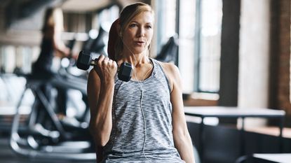 A mature woman lifting weights at the gym