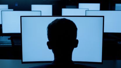 A stock photo of a man staring at a computer screen.