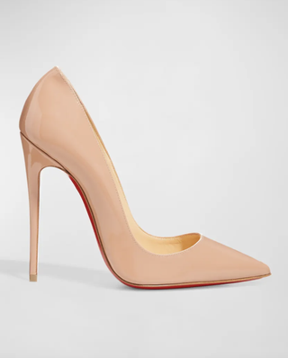 a pair of blush louboutin heels in front of a plain backdrop