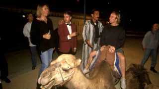 Def Leppard’s Joe Elliott watches Phil Collen sitting on a camel