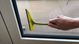 A squeegee being used on a window pane