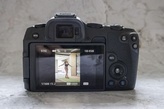 Canon EOS R8 camera on table, rear screen, with plain background