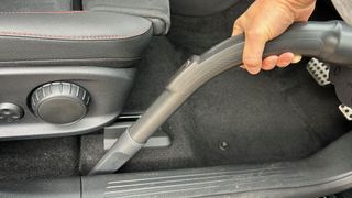 Detail tool on Miele Boost CX1 vacuum cleaner being used to get into crevices in a car