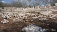The foreground of an unearthed palace-like Mayan building.