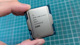 Intel Core Ultra 5 245K processor held in front of cutting mat