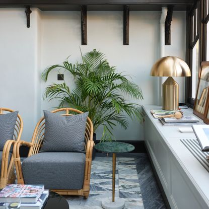 A living room with rattan seating and a large gold-tone mushroom table lamp