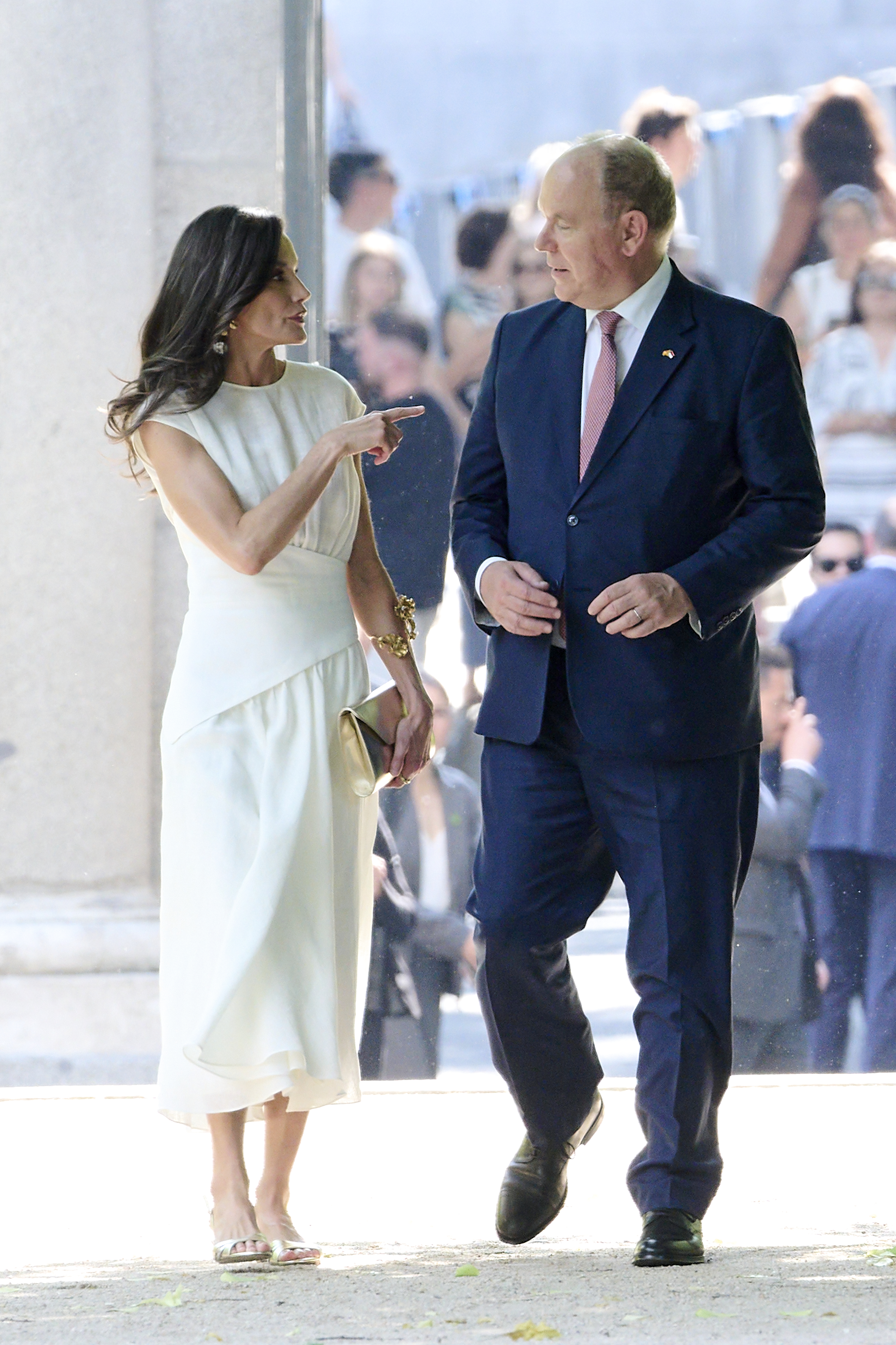 Queen Letizia wearing a white dress pointing at Prince Albert