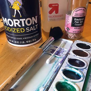 Watercolour palette, bottles of salt, paintbrush, cotton bud and rubbing alcohol
