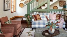 Rustic great room featuring an eclectic mix of wall art, collected objects, and upholstered furniture &ndash; the gingham loveseat being the most statement-making of the bunch