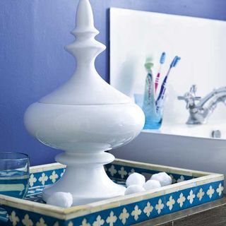 bathroom with blue wall and decorative blue tray as dressing table and sleek jars