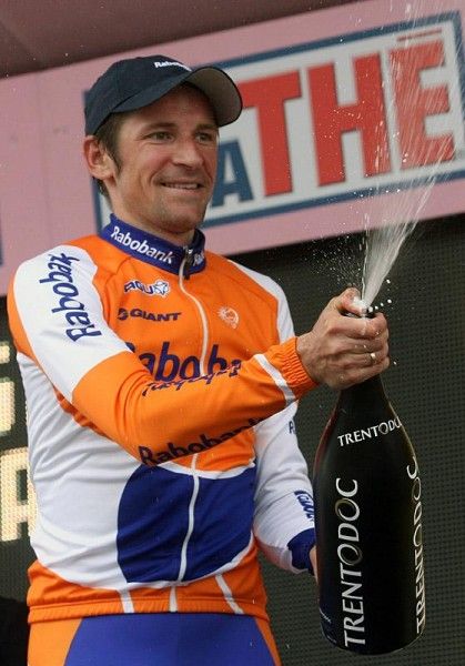 Stage winner Denis Menchov uncorks the bubbly on the podium.