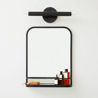 Seamless Wall Shelf Mirror in bathroom hanging on wall with toiletries and brush stored on the shelf