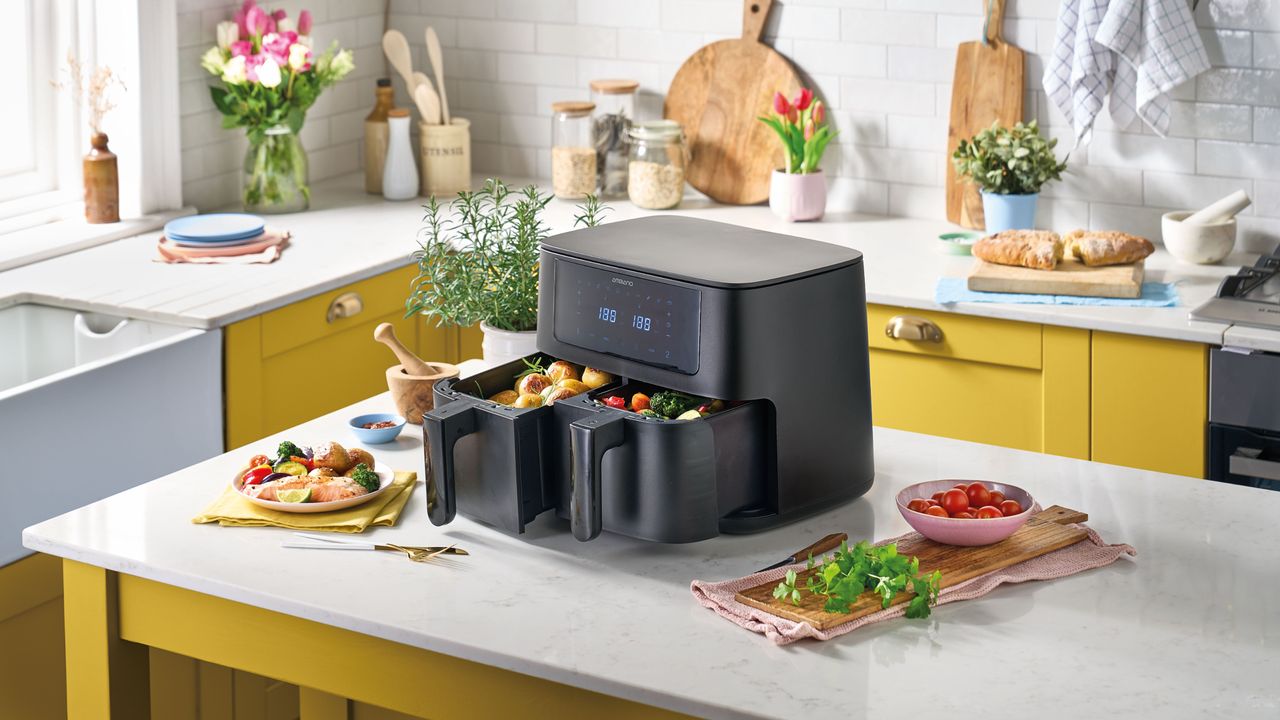 Aldi dual basket air fryer on kitchen worktop surrounded by cooked dishes