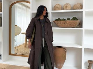 Fashion influencer @monikh wearing a brown coat in her home in London.