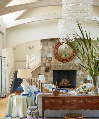 living room with white walls and fireplace and basket chairs and fish light sculptures and view to stairs