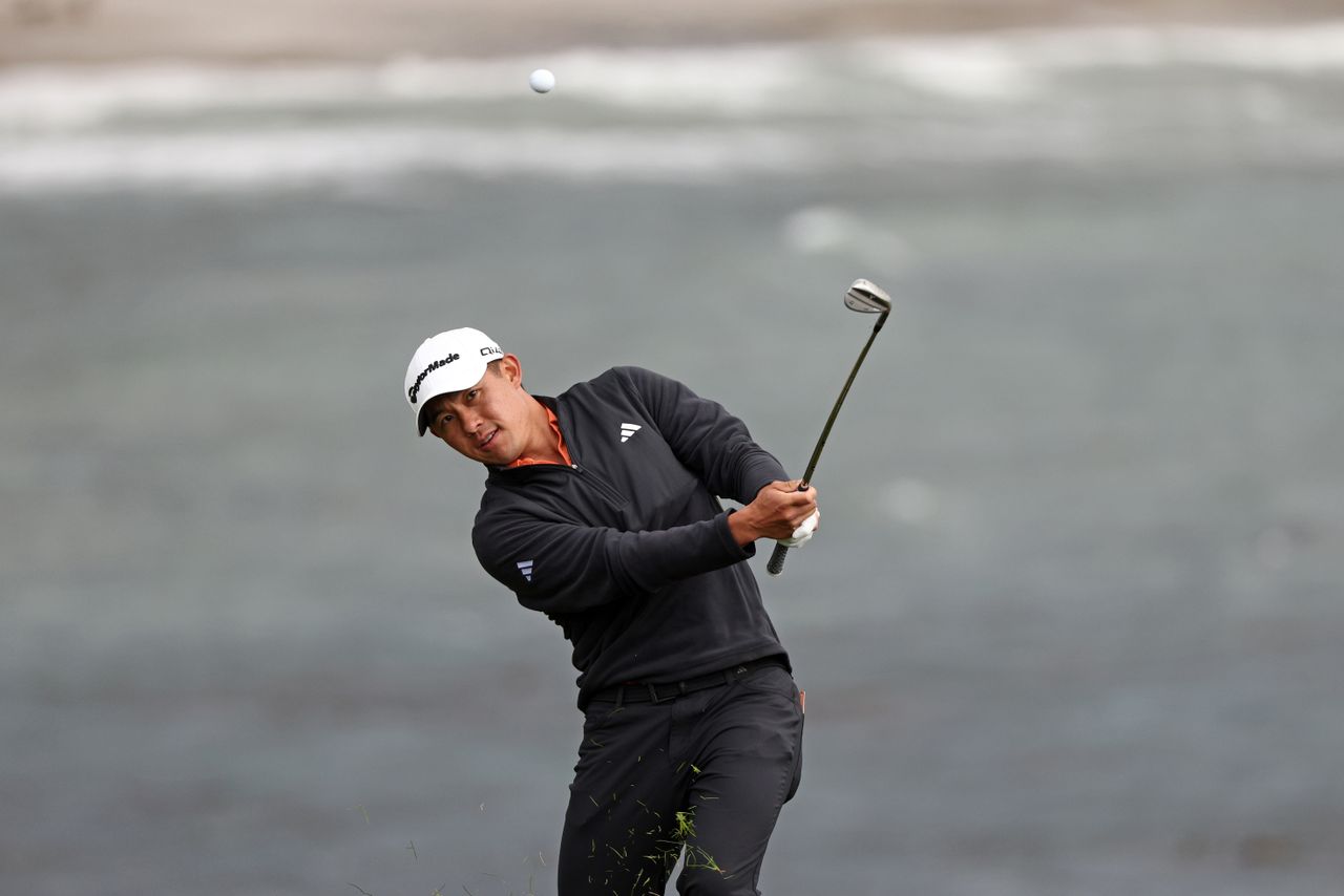 Collin Morikawa hits a wedge shot from the rough
