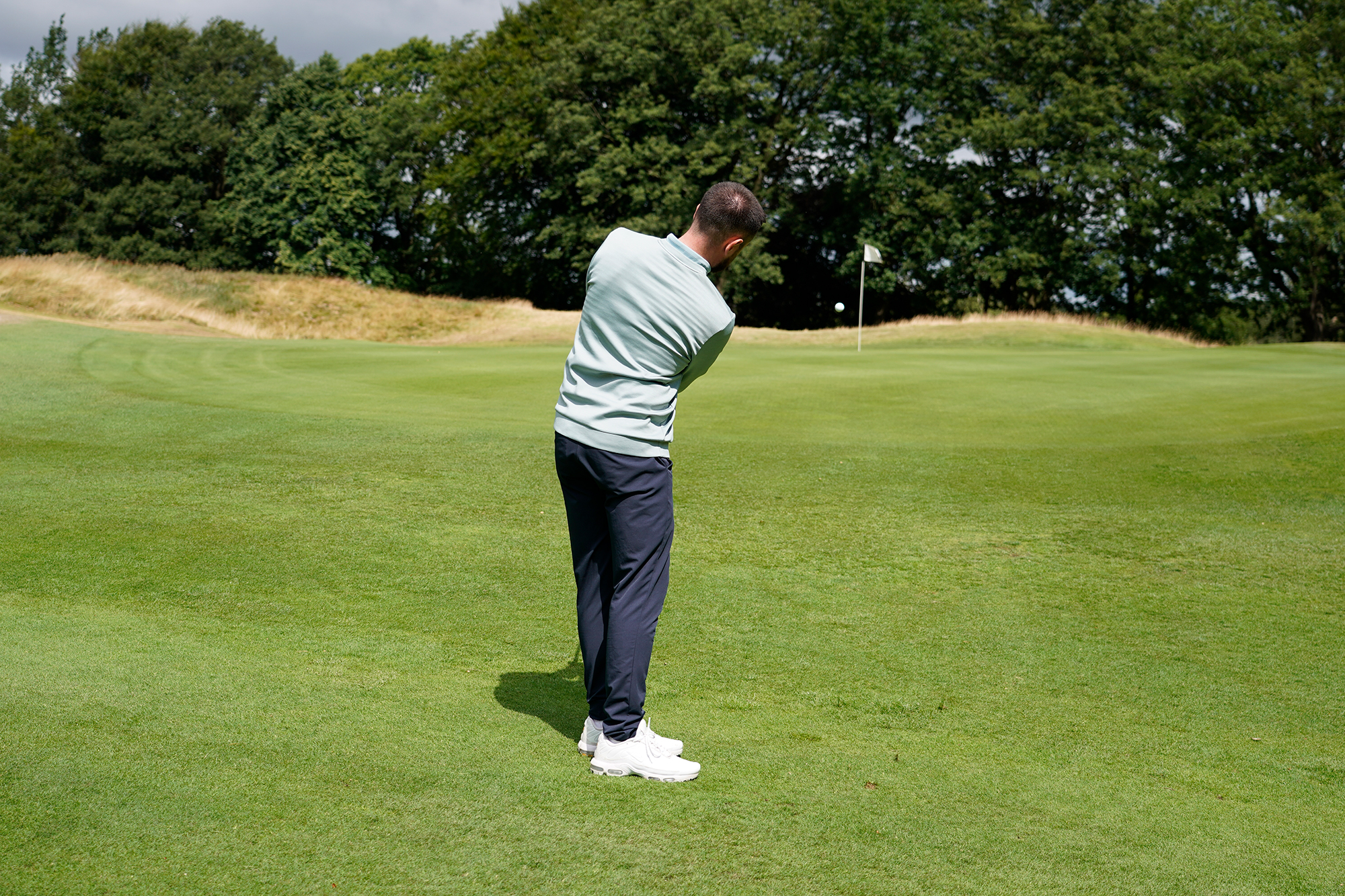 Baz Plummer hitting a chip shot from inside 50 yards towards a back pin on the 11th green at Sand Moor Golf Club