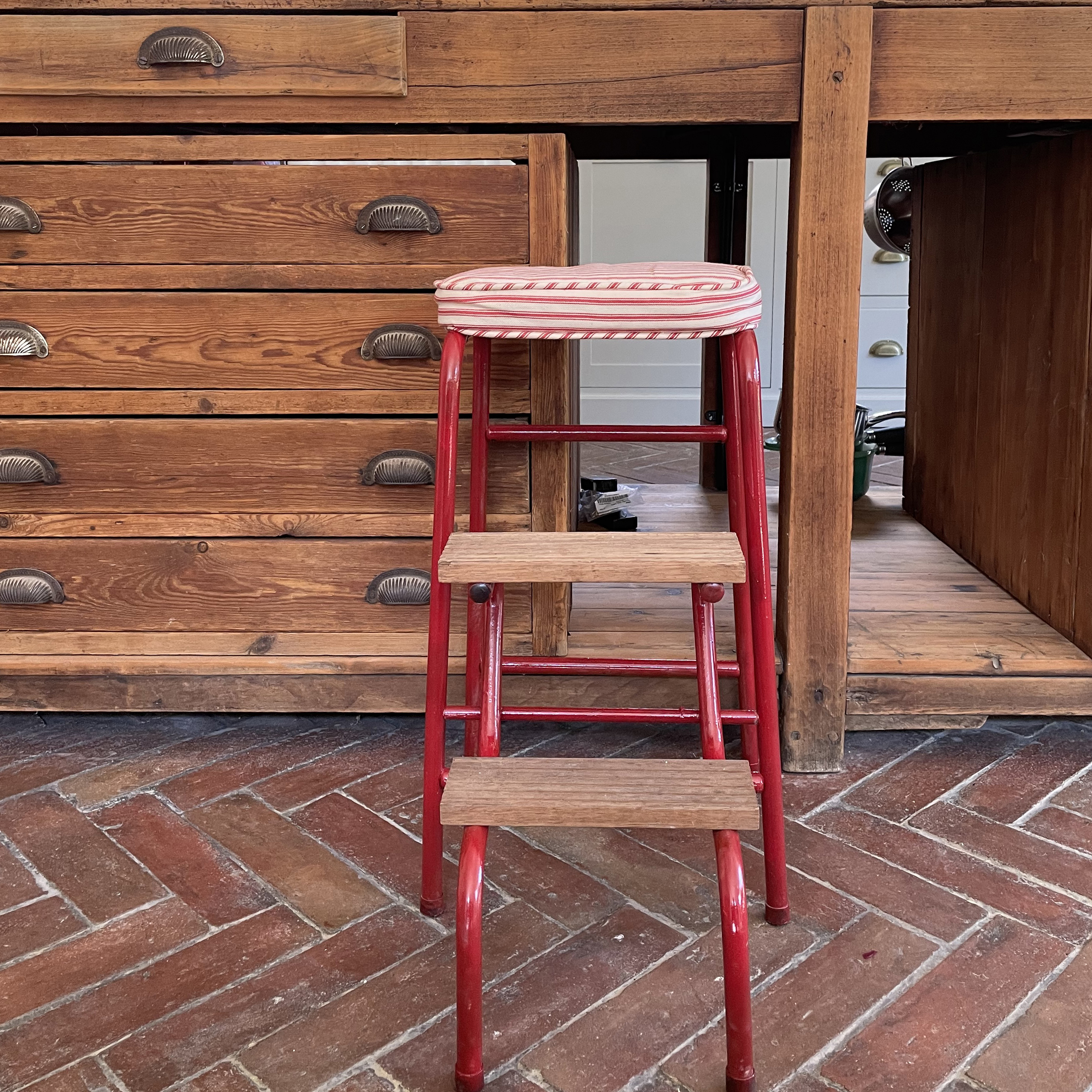 painted red vintage stools in front of a wood cabinet