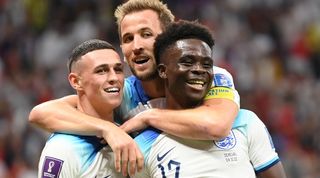 Phil Foden and Harry Kane celebrate with Bukayo Saka after England's third goal against Senegal at the 2022 World Cup.