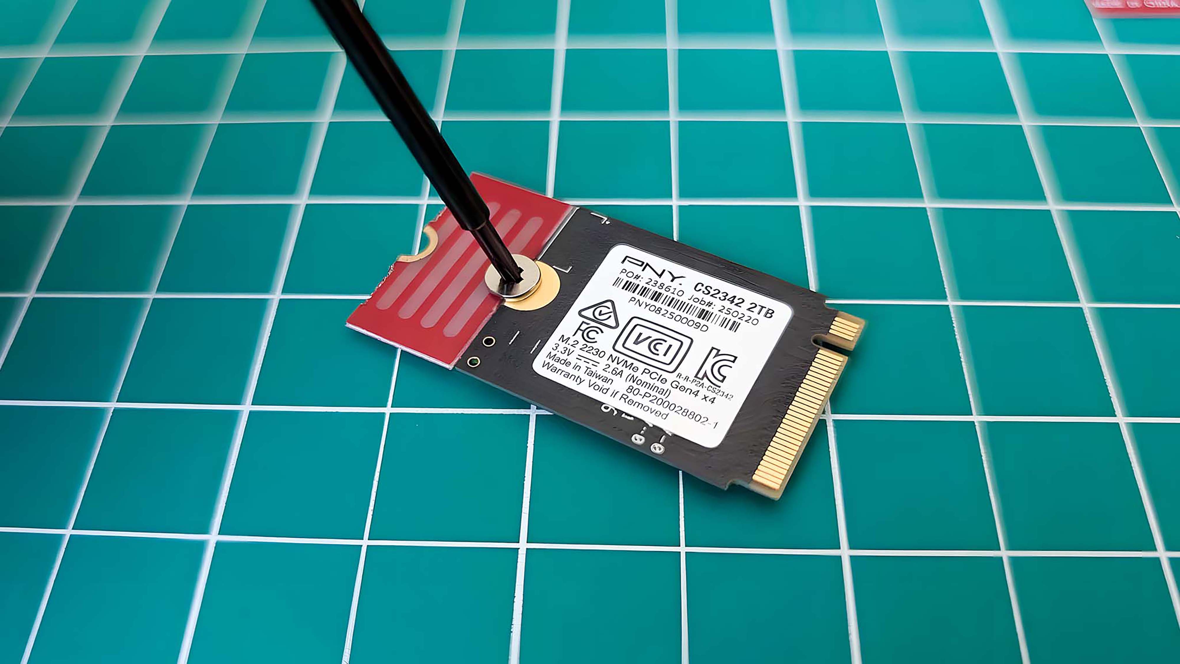 A screw driver connecting the SSD extender to an SSD.