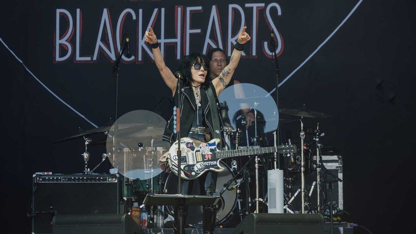 Joan Jett onstage raising her arms aloft