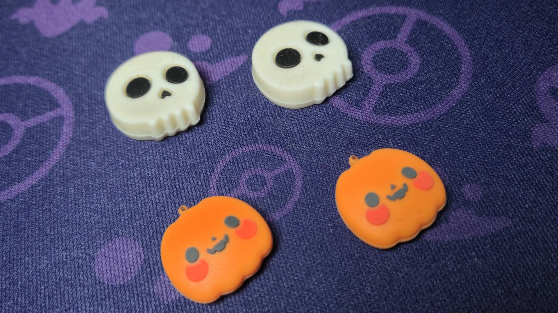 Photo of two pairs of GeekShare thumb grips sitting on a purple gaming mouse mat.