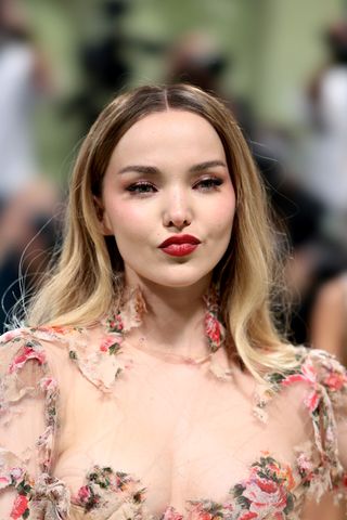 A woman, Dove Cameron, with rosy pink blush on the 2024 Met Gala red carpet.
