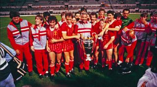 Liverpool players and staff celebrate with the trophy after their European Cup final win in 1984.