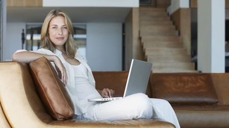 Woman in modern-style open plan room using laptop computer