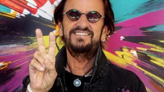 Ringo Starr art; a man in sunglasses in front of a colourful painting