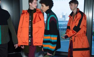Male models dressed in Orange and black with stripes jackets from the Kenzo AW15 collection