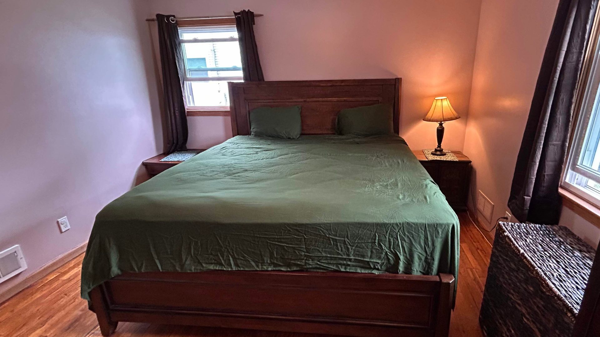 Sijo Airyweight Eucalyptus sheet set on our reviewer&#039;s bed with an open window and side table with a night lamp next to the bed