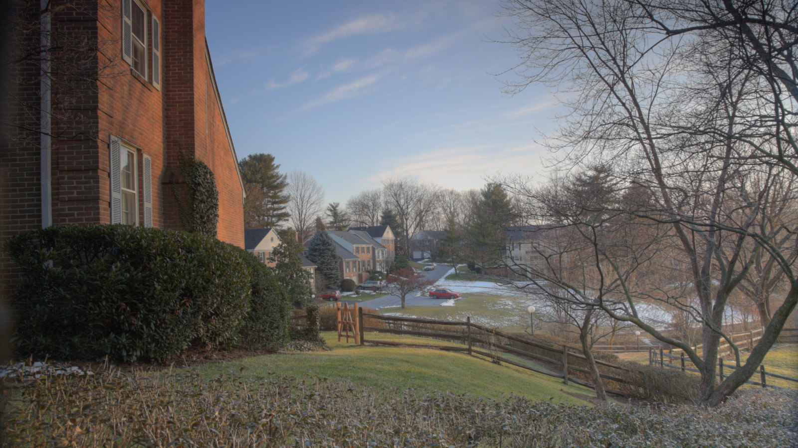 A suburban neighbourhood with trees in front yards bare of leaves during the winter