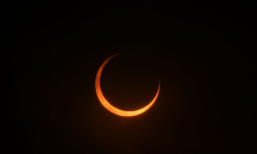 the sun takes on a orange hue and is shaped like a thin crescent, which also looks like horns.