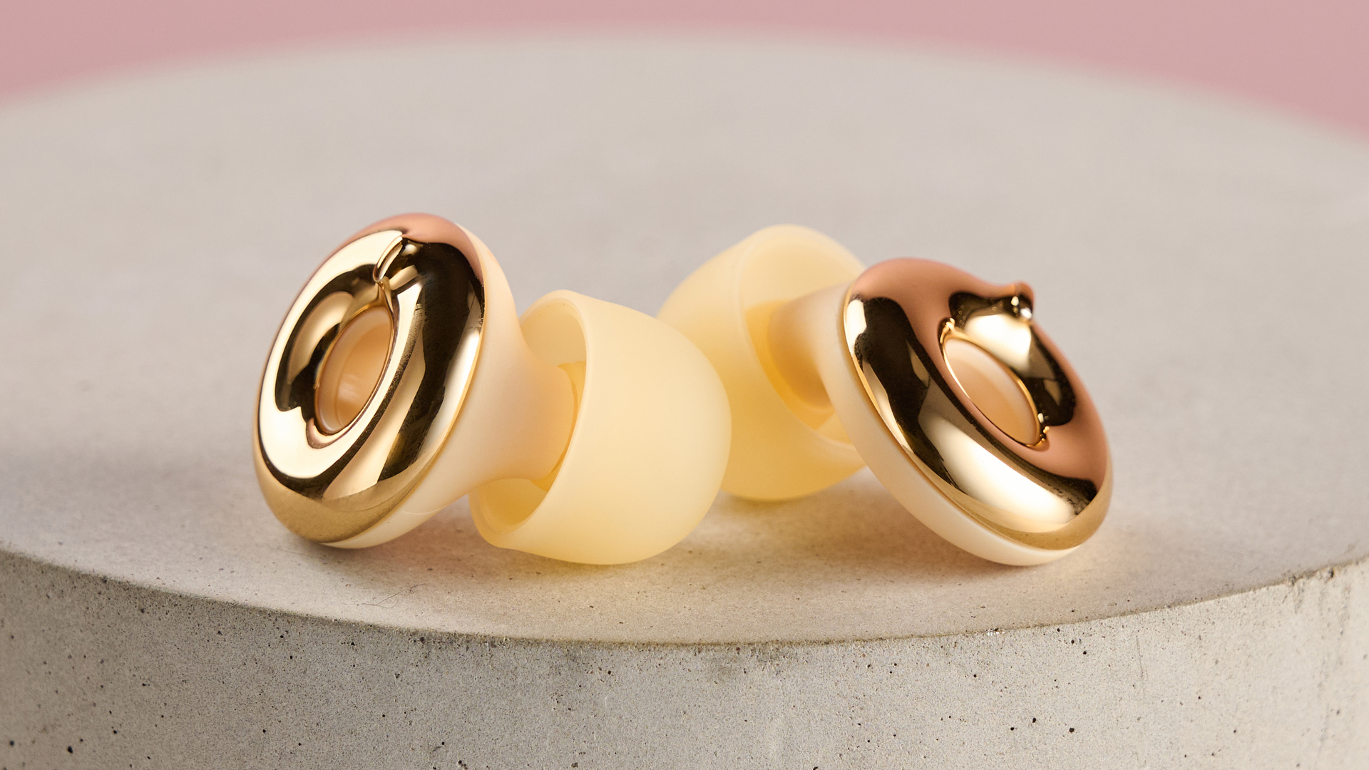 A close-up of the gold Loop Switch 2 earbuds.