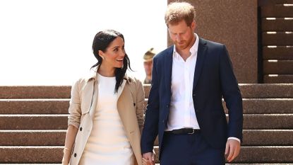 Prince Harry and Meghan Markle look lovingly at each other while descending stairs