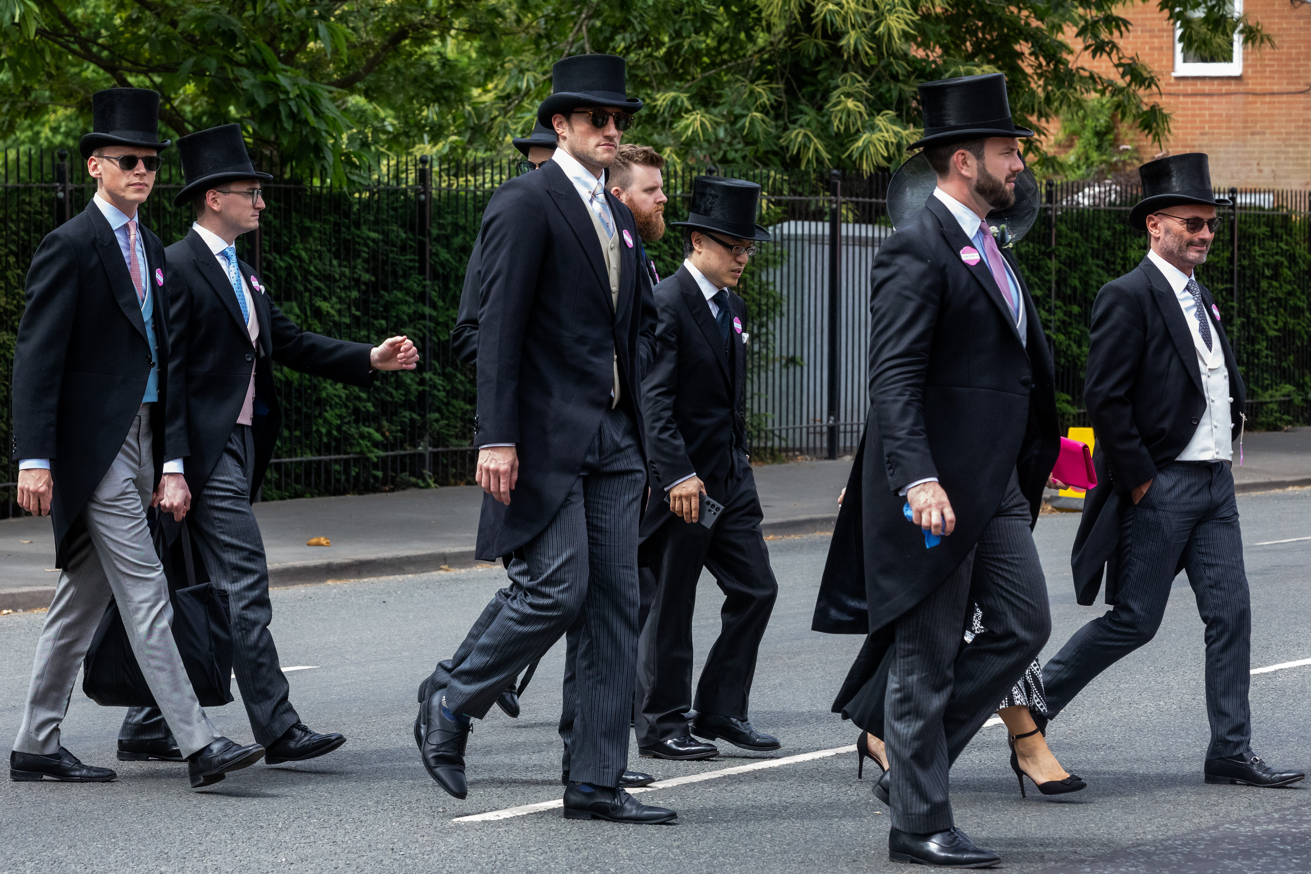 A group of men crossing the road in morning dress and top hats