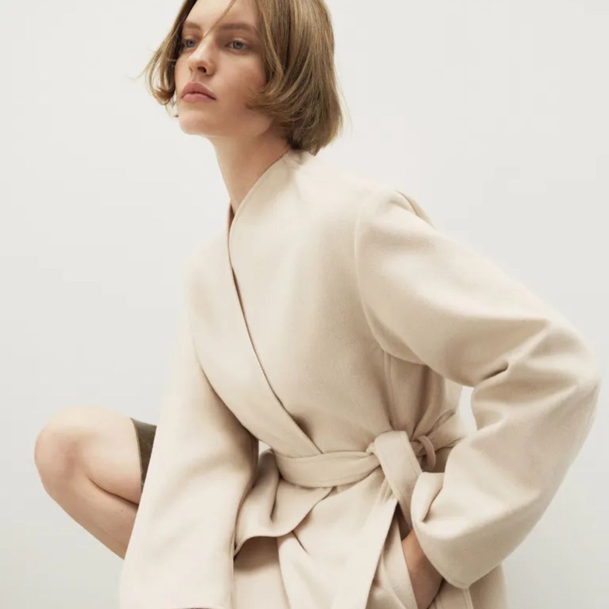 Model wears a cream collarless jacket