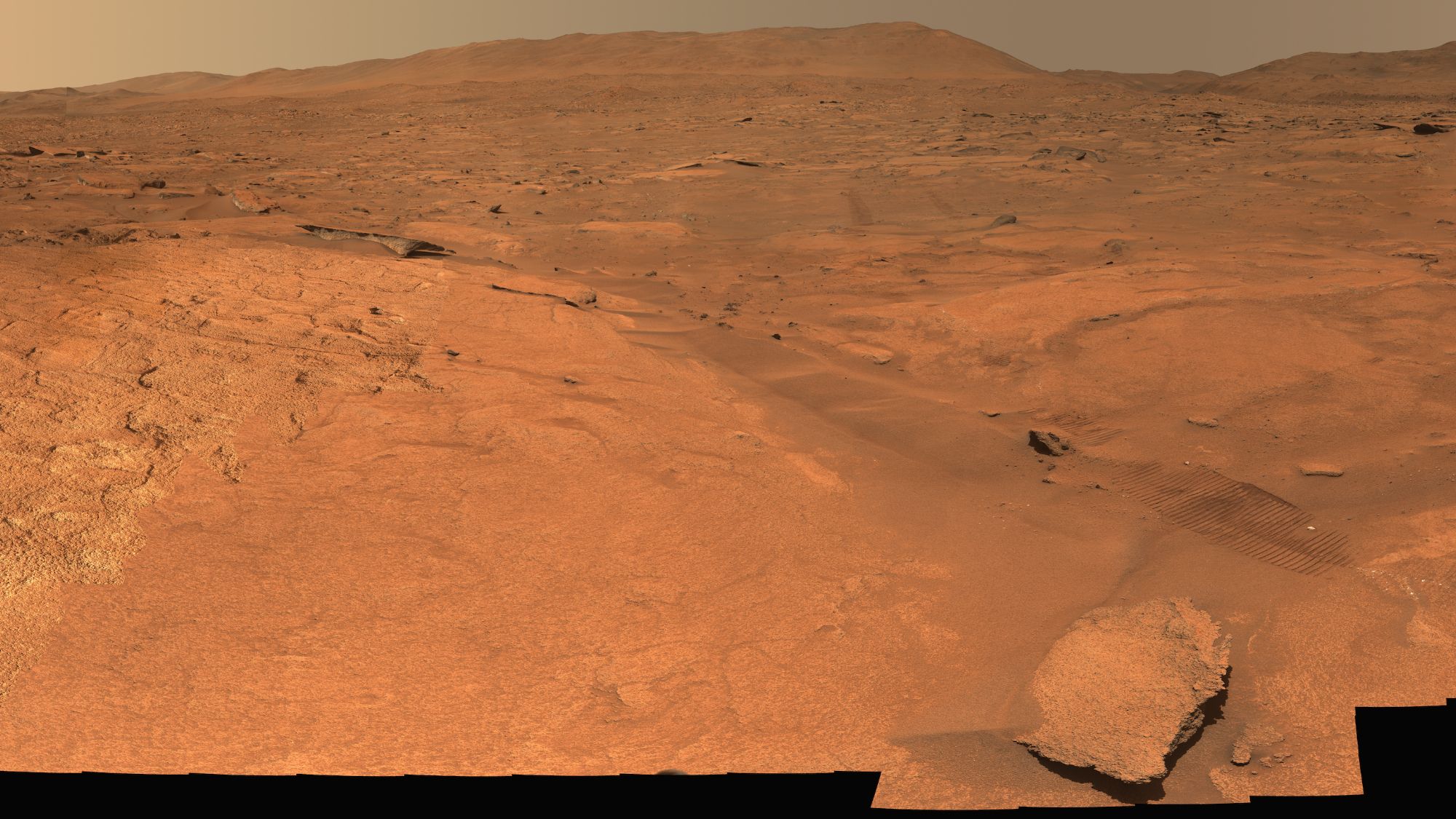 A view of a region of Mars with some rocks strewn about.