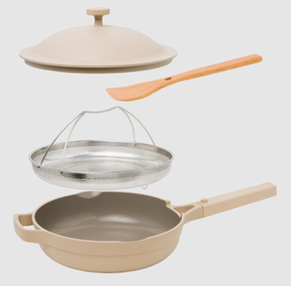 The Always Pan made by Our Place in light gray with steamer and spoon