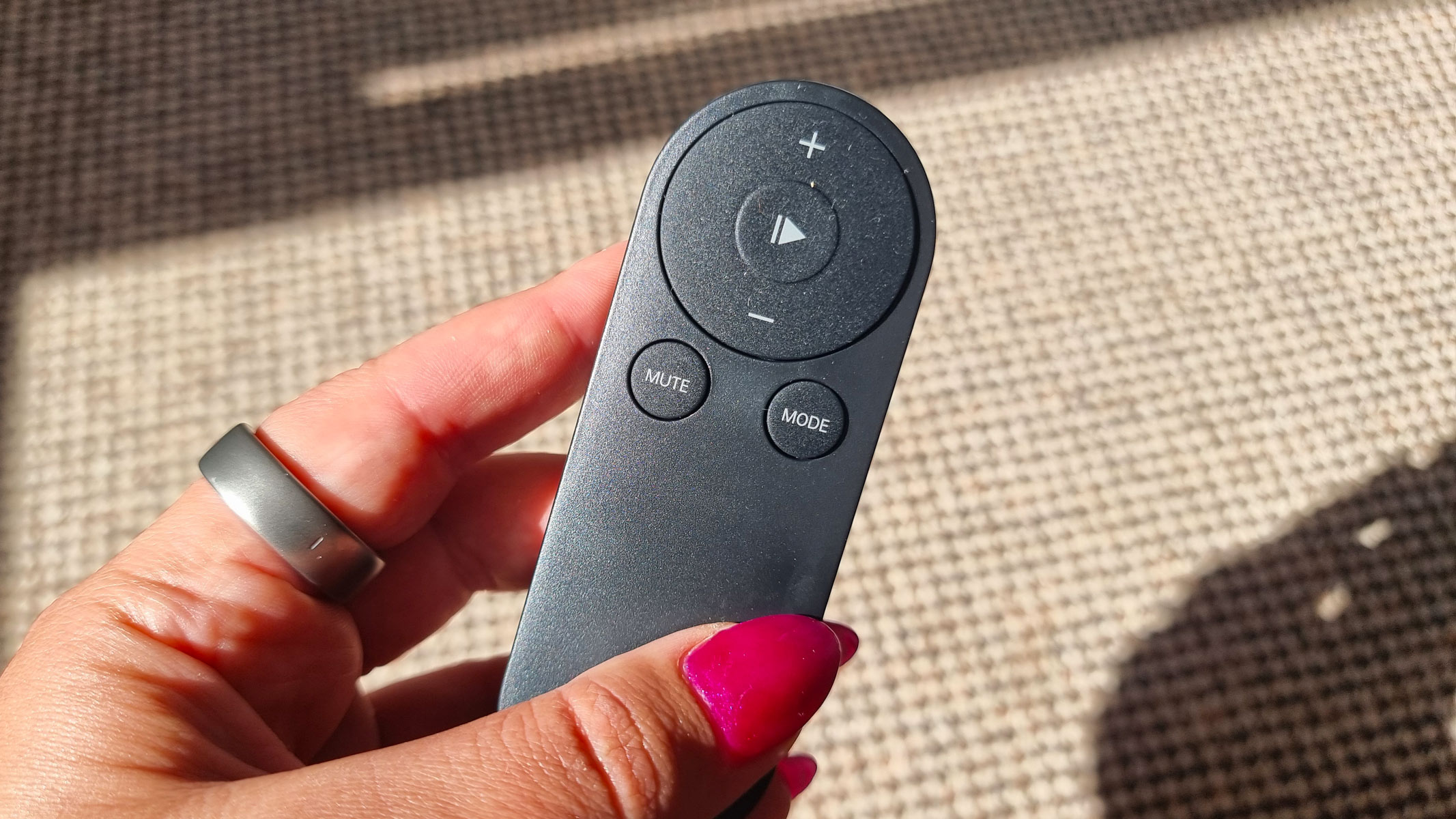 Our reviewer holding a remote control for the Urevo SpaceWalk E4W treadmill